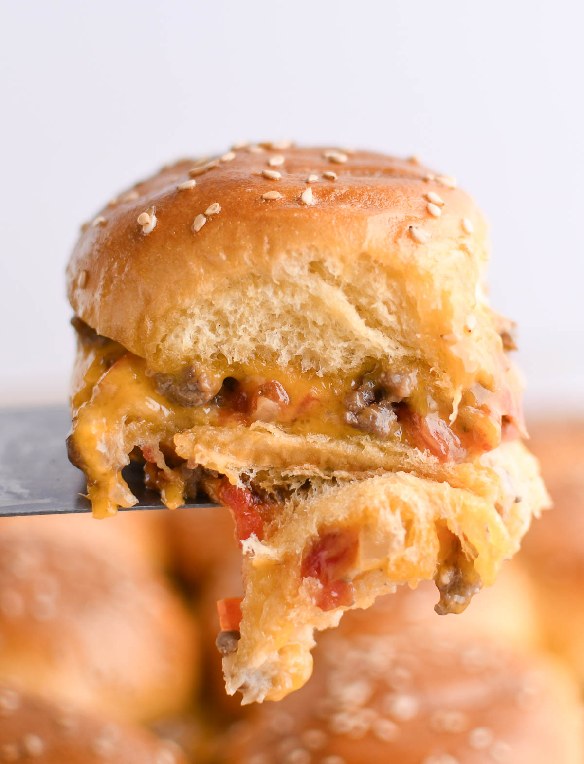 A close up image of a Glazed Cheeseburger Slider on Hawaiian Rolls