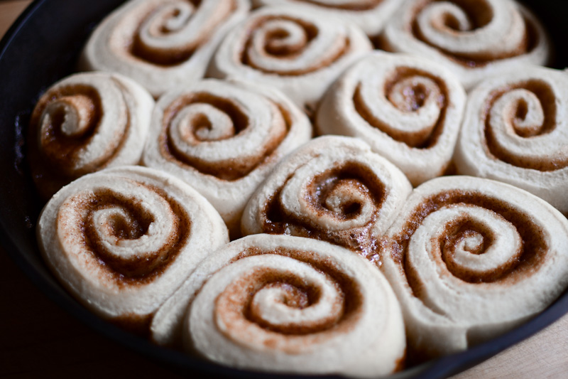 A pan of baked sourdough cinnamon rolls waiting to be frosted. 