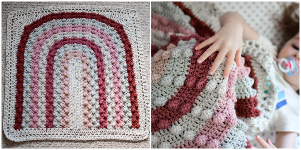 A rainbow bobble blanket made in varying shades of burgundy, pinks, and creams. 
