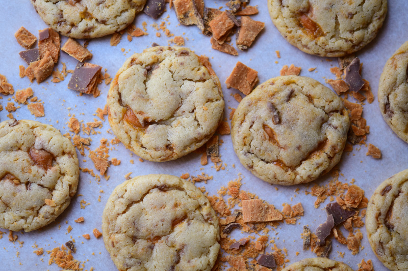 An easy recipe for soft & chewy butterfinger cookies. These fun cookies have crisp edges, chewy centers and are filled with butterfinger bits. 