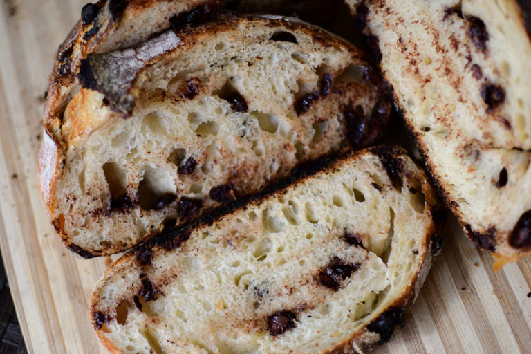 A loaf of chocolate chip sourdough bread on a cutting board