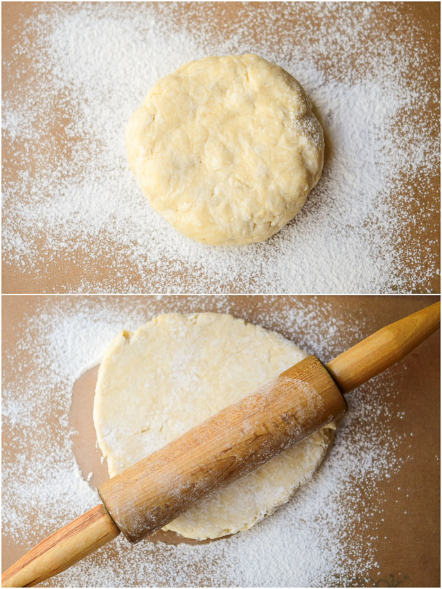 A disc of pie dough on a floured surface with a rolling pin
