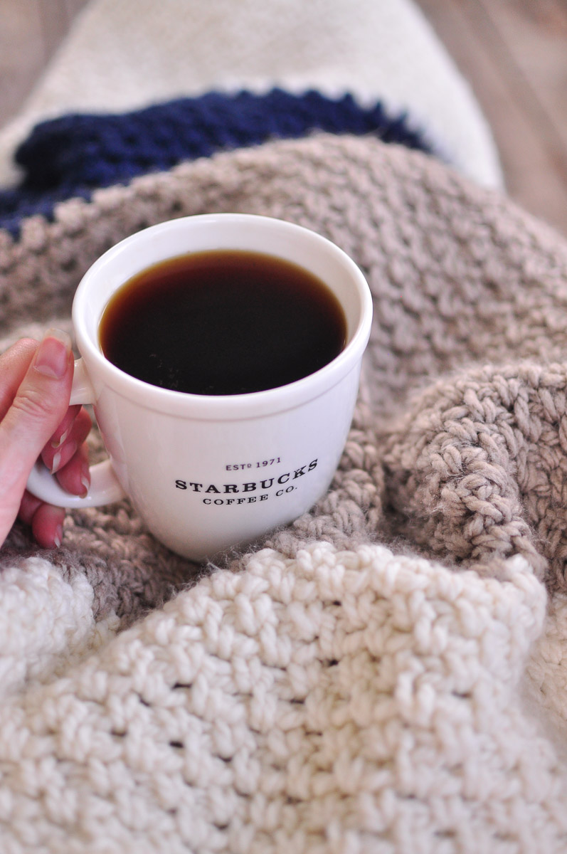 A blanket crocheted with the moss stitch and a cup of black coffee