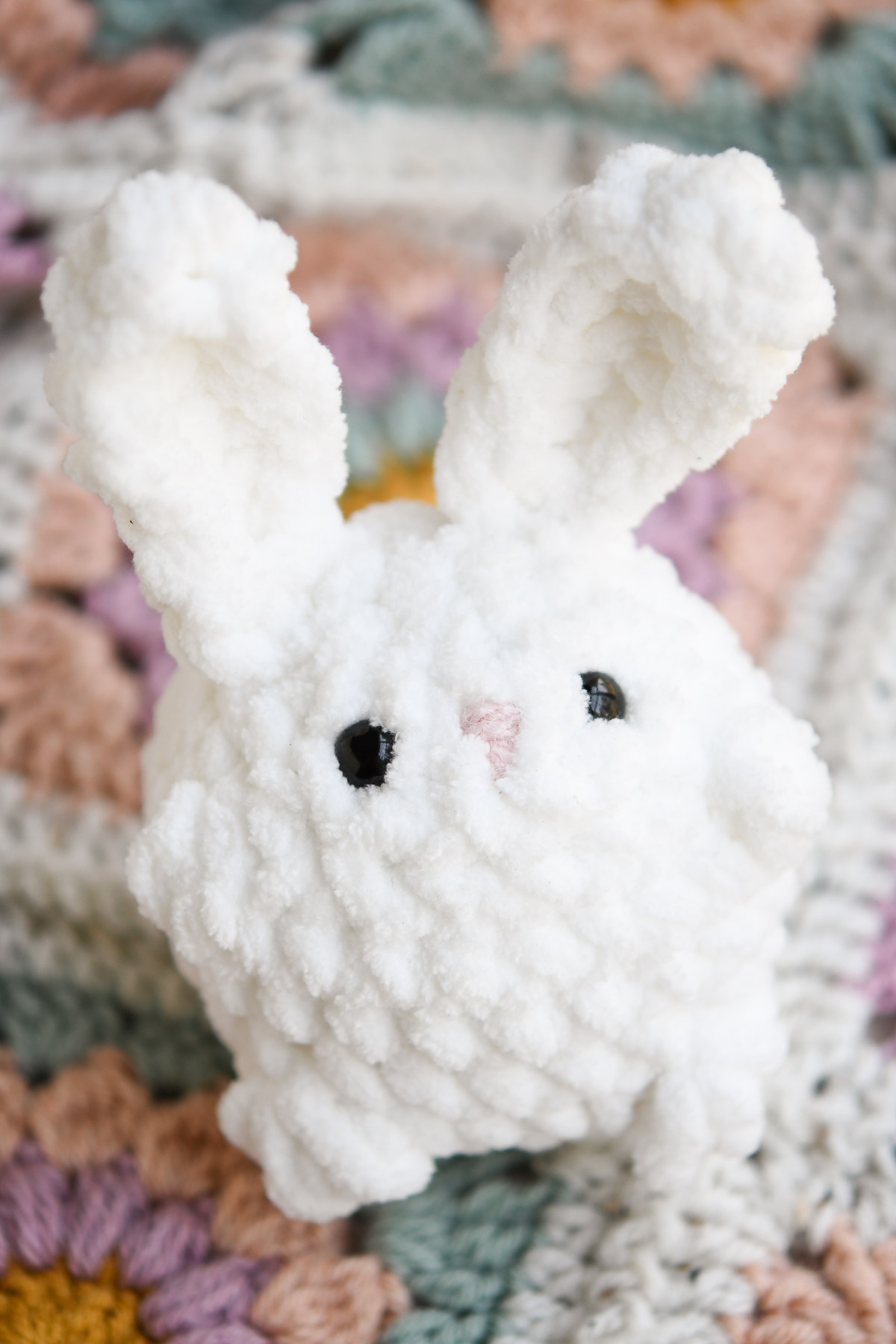 A mini crochet bunny on a sunburst granny blanket