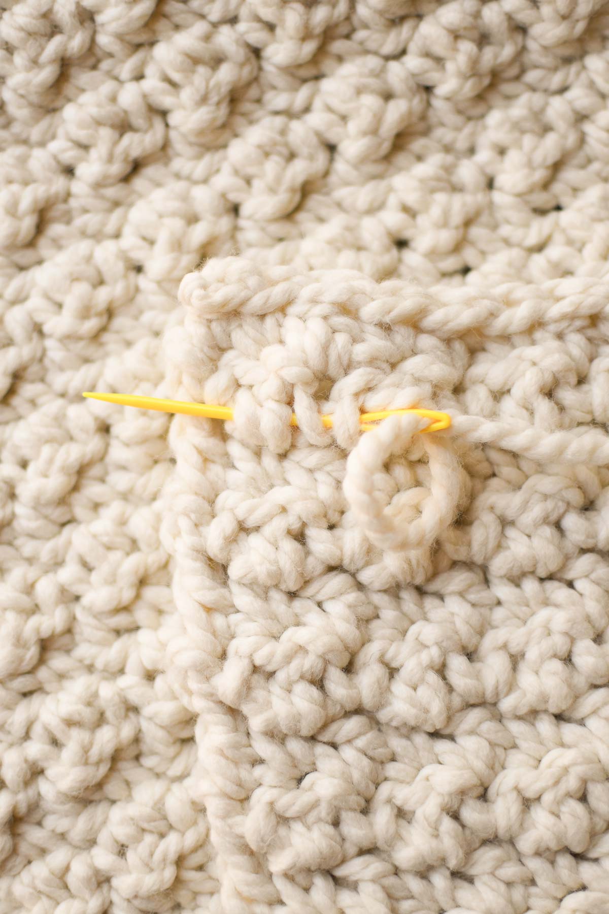 Close up of weaving in final ends to finish the blanket.