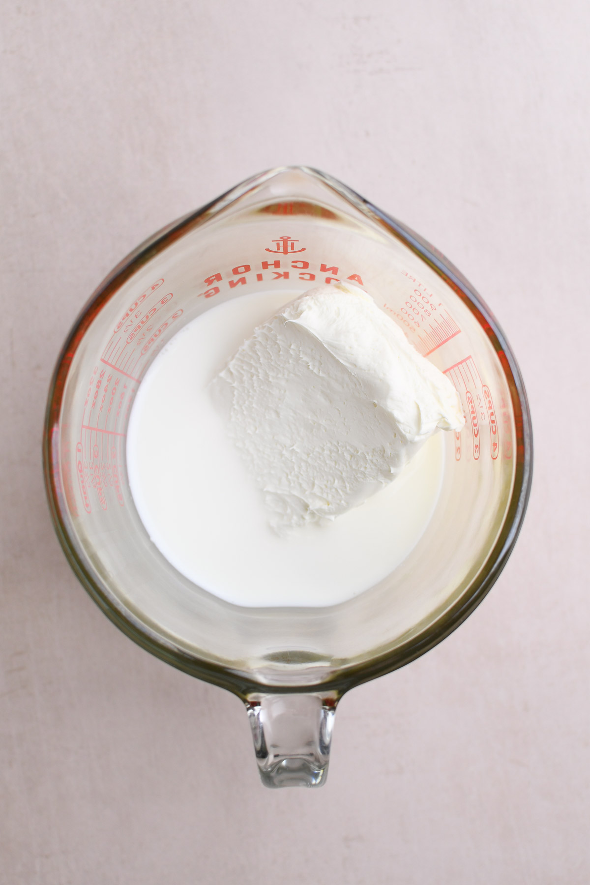 A bowl of milk and cream cheese before warming