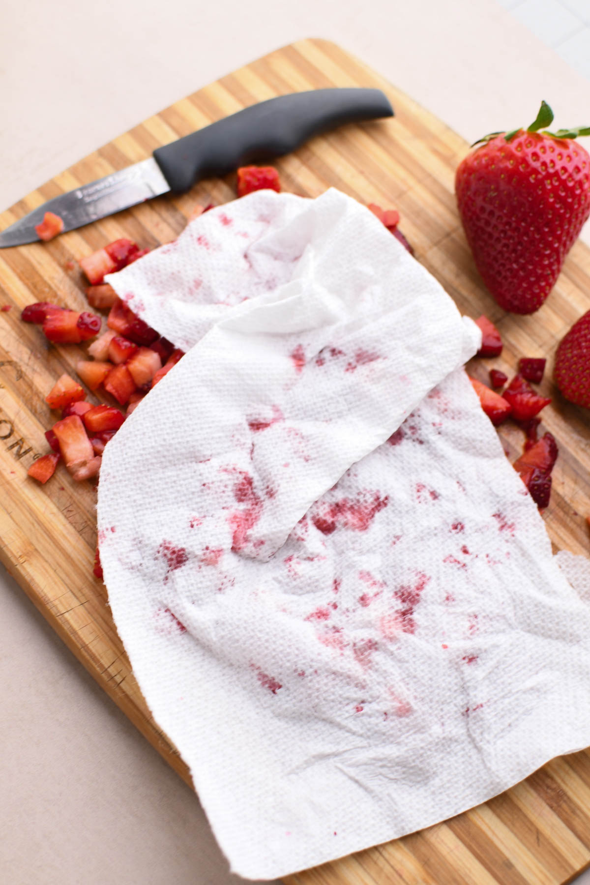 Blotting excess moisture from chopped strawberries