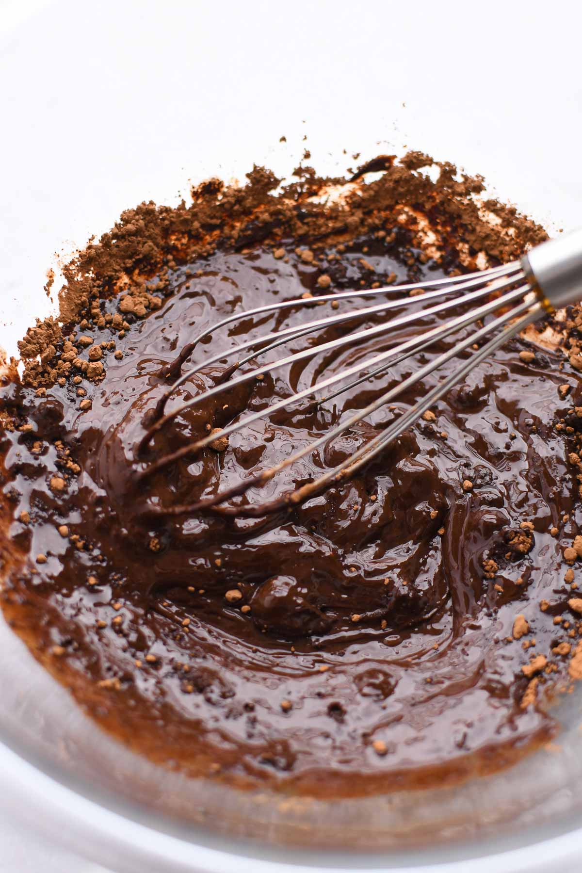 Whisking together the melted butter and chocolates. 