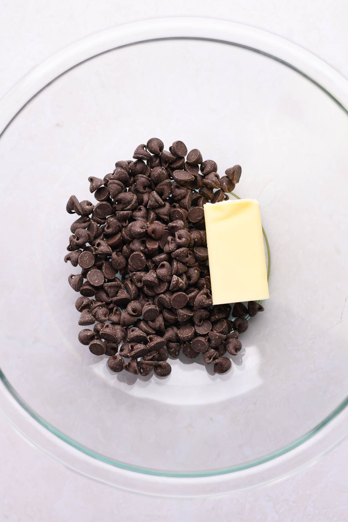 A mixing bowl with chocolate chips and butter.