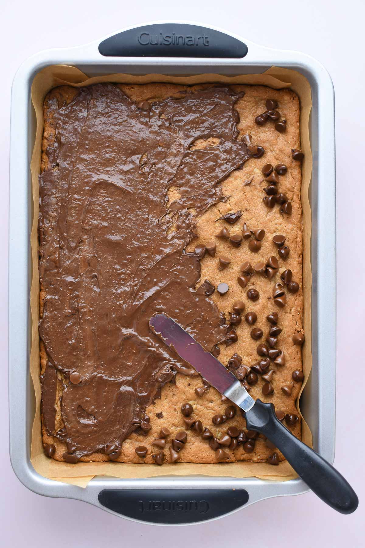 Spreading the warm chocolate evenly over the cookie. 