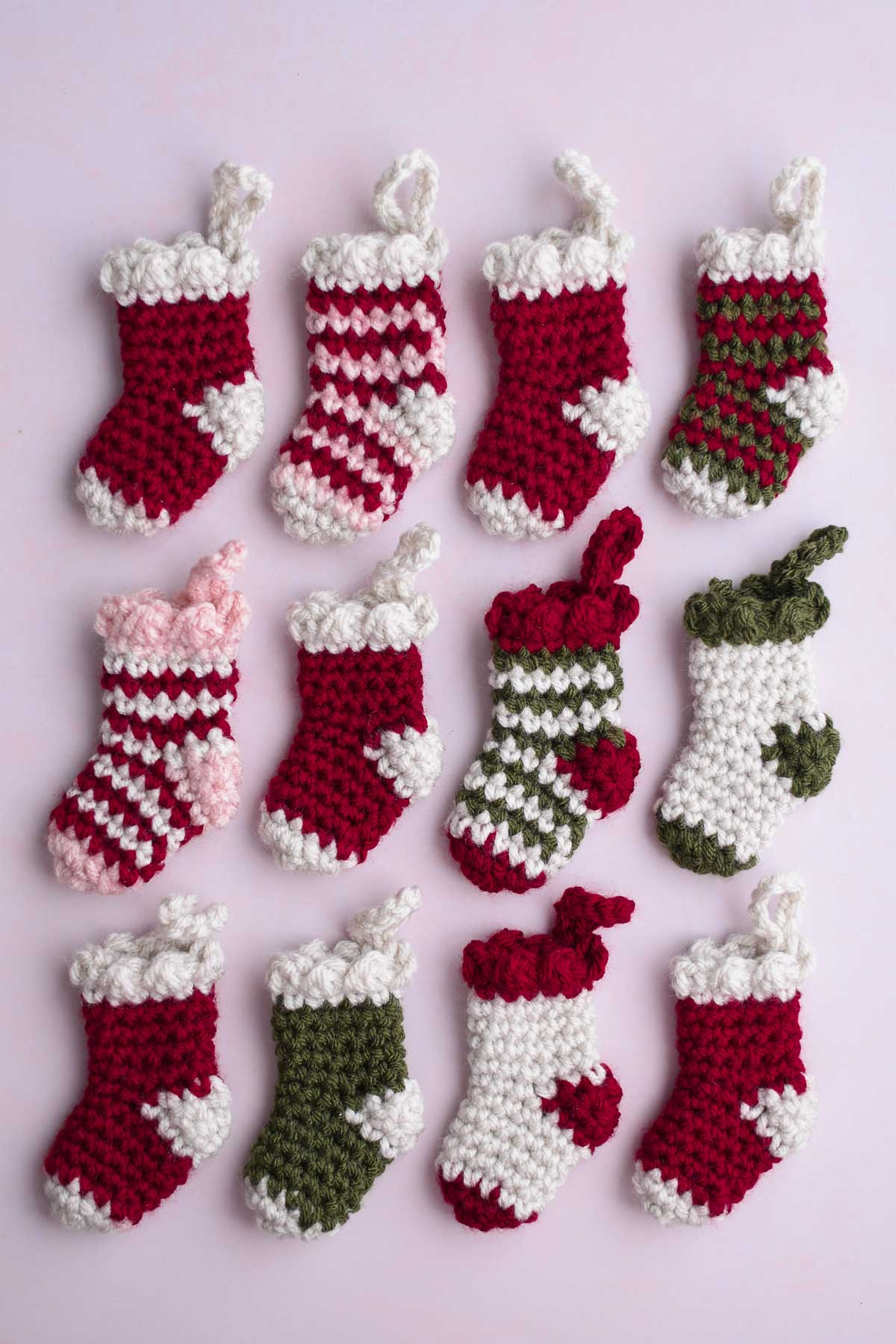 12 mini crochet stockings in different patterns lined up in a 3x4 grid.
